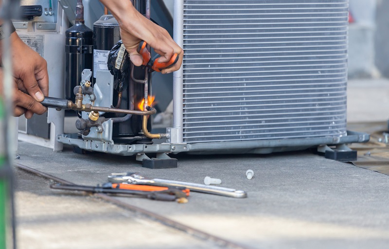 Technician performing HVAC maintenance